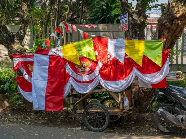 Banten, Indonesia - August 13, 2022: A street vendor selling Indonesian flags with many variations along with other Independence Day ornaments on a sunny morning.