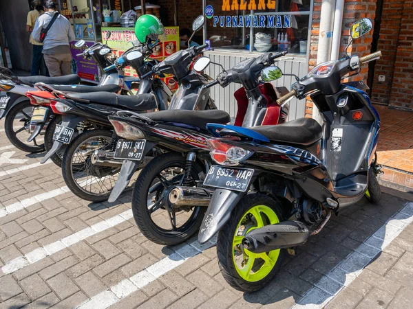 Banten, Indonesia - August 13, 2022: Five motorcycles parking at a local food court showing F&B brand name words on a sunny morning.