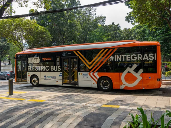 Jakarta, Indonesia - August 19, 2022: A full display of a long electric city bus serving between trip points in Jakarta area on a sunny morning.