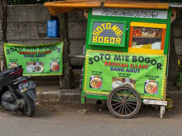 Banten, Indonesia - August 11, 2022: A green push cart selling traditional noodle soup with writings saying 
