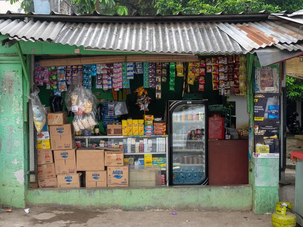 Jakarta, Indonesia - August 9, 2022: Indonesia's traditional grocery store typically displaying hanging sachets of cleaning substances, powdered drinks, and snacks, along with transparent displays.