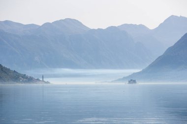 beautiful view of mountains and lake on the background of the sea, the sun and a blue sky.