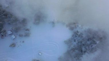 Great aerial footage in 4K of a wintry dream landscape in the Swiss mountains with a mystical mood because of the fog.
