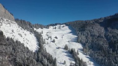 Great aerial footage in 4K around a big mountain in the canton of Schwyz in Switzerland in winter.