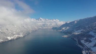 Great aerial footage in 4K over a lake in the canton of Glarus in Switzerland with a dreamy winter landscape in the background.
