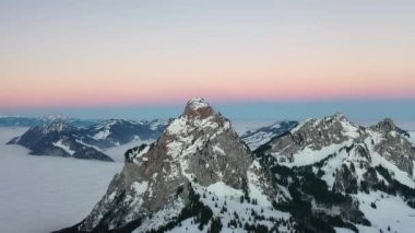 Great 4K aerial footage of a wintry dream landscape in Switzerland during a colorful winter sunrise.