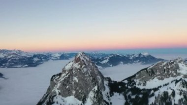 Great 4K aerial footage of an epic sea of fog behind the mountain called Grosser Mythen in central Switzerland on this beautiful sunrise.