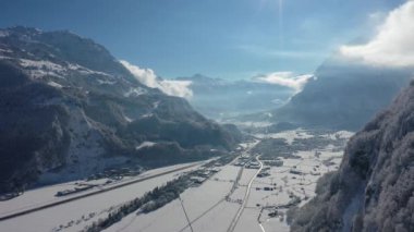 Great 4K aerial footage over a snowy forest on a sunny day in the canton of Glarus in Switzerland.