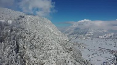 Great 4K aerial footage of the trees in the Swiss mountains covered in snow from the blizzard.