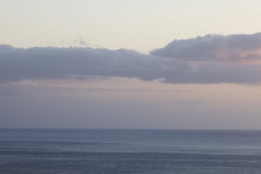 Great drone shot over the sea on a beautiful spring sunset with some boats in the foreground.