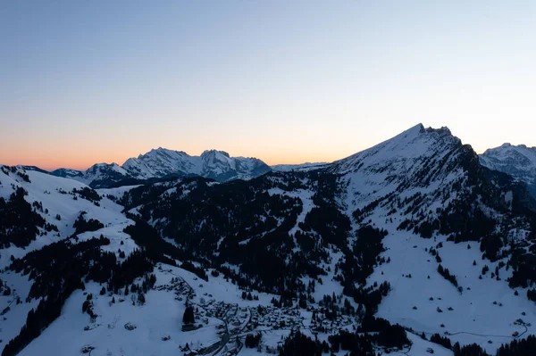 Great drone photo over the Swiss Alps at an epic sunrise with a pink horizon.