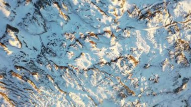 Great 4K aerial footage of a bird's eye view of a road and pasture halfway covered by snow.