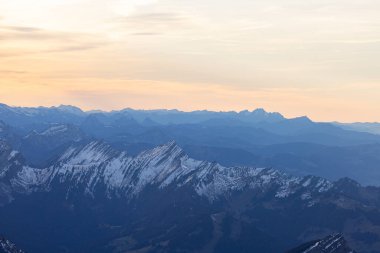 Beautiful colored horizon with red, orange and pink tones behind the mountains of Switzerland.