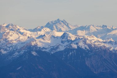 Shot from behind the peaks of the Swiss mountains during the golden hour, perfect for photography.