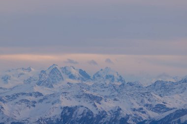 Beautiful colored horizon with red, orange and pink tones behind the mountains of Switzerland.