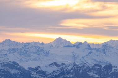 Beautiful colored horizon with red, orange and pink tones behind the mountains of Switzerland.