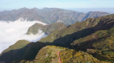 Aerial high above clouds and mountain landscape of Madeira island, Portugal.