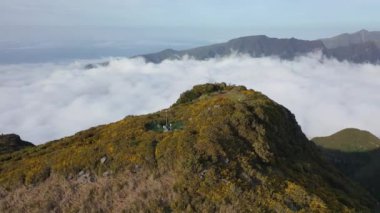 Great sightseeing flight around a hill called Bica da Cana in Madeira, Portugal with a gigantic sea of clouds in the background.