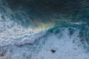 Great waves in the Atlantic Ocean that are illuminated by the sun and therefore shine so beautifully.