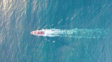 Superb aerial footage during the golden hour of a fishing boat going out to sea in the Atlantic Ocean.