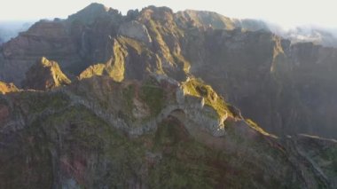 Madeira dağlarının tepelerinde destansı bir altın saat gün doğumunun 4K hava görüntüsü..