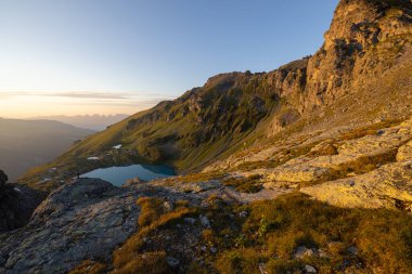 A wonderful view to the horizon at a beautiful sunset in the alps of Switzerland by an alpine lake called Schottensee. These colors by the sunset are just amazing. Epic clear blue water.