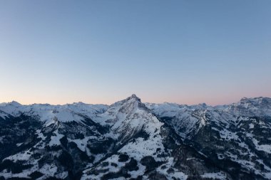 A colorful sunrise over Lake Walen in the canton of Glarus in Switzerland. In the background the snow-capped mountains.