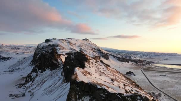 赤い空と日当たりの良い山のピークを持つ栄光の日の出にSkogafoss近くのアイスランドの4K空撮 — ストック動画