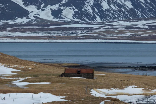 冰岛北部大西洋对岸的一片草地上的一个小木屋 在一座叫柯库瀑布的山前 — 图库照片