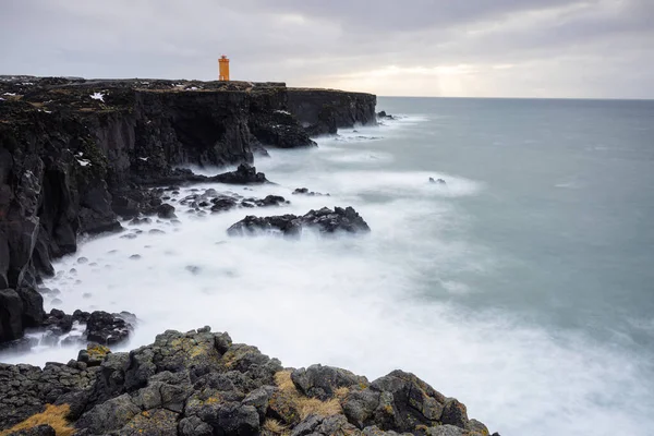 长期暴露在冰岛悬崖上 地平线上有一座橙色灯塔 — 图库照片