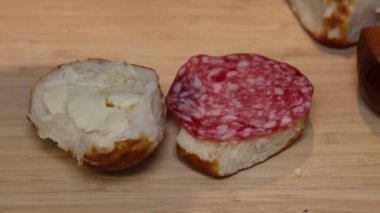A piece of salami is placed on a lye bread smeared with butter.
