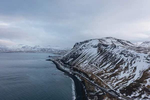 ドローンで撮影されたアイスランド北部の海岸の雪に覆われた丘陵地帯 — ストック写真