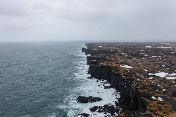 冰岛海岸是由黑色的火山岩构成的 在暴风雨中巨浪冲撞的地方非常陡峭 — 图库照片