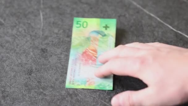 彼らは現在約同じ価値があるので 男は50フラン紙幣の横に50ユーロのノートを置きます — ストック動画