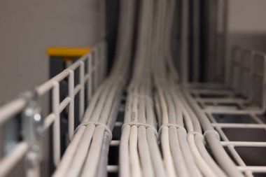 Elektrik kabloları yumuşak bir bokeh ile kablo kanalına bağlı..