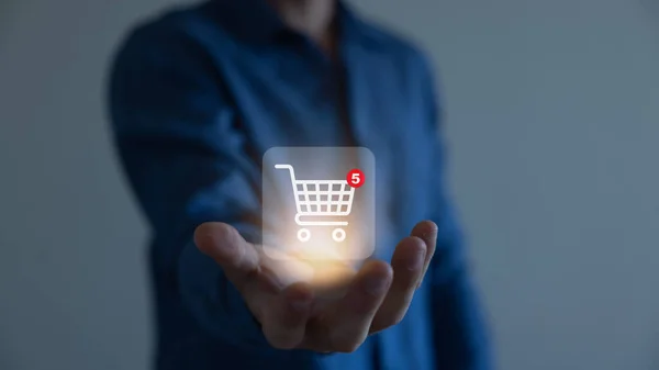 İş adamı online alışveriş kavramına sahip akıllı telefonu, online alışveriş arabasının sanal arayüzüne sahip pazar sitesi ağın bir parçası, alışveriş arabasının seçimiyle çevrimiçi alışveriş işi.