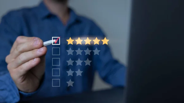 Müşterinin akıllı telefondan 5 yıldızlı reyting vermesine yakın çekim. Teftiş, Hizmet derecesi, memnuniyet, Müşteri hizmetleri deneyimi ve memnuniyet anketi kavramının kullanımı.