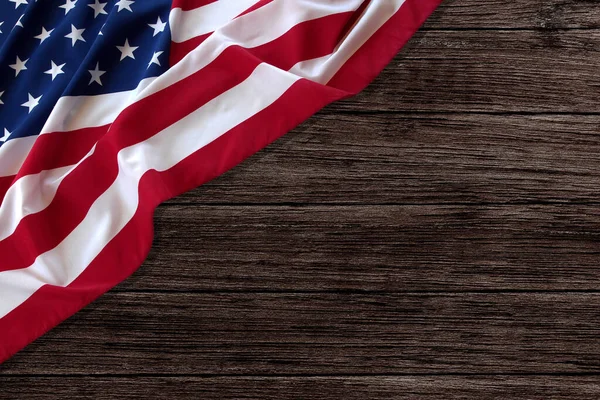 Stars and stripes American flag on rustic wooden background, copy space. The pride of the American people. Symbol of independence, freedom and patriotism in the USA.
