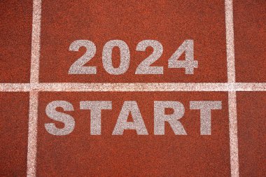 Mutlu yıllar 2024, yeni yılın başlangıcını simgeliyor. 2024 yılına kazınmış atletizm pistinde koşmaya hazırlanan bir adamın arka görünüşü. Başarının amacı. Yeni yıla hazırlanıyorum..