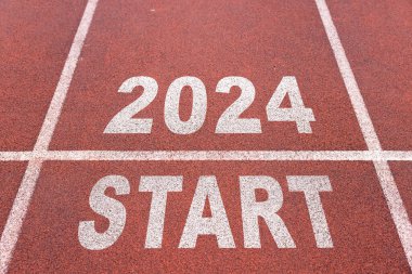 Mutlu yıllar 2024, yeni yılın başlangıcını simgeliyor. 2024 yılına kazınmış atletizm pistinde koşmaya hazırlanan bir adamın arka görünüşü. Başarının amacı. Yeni yıla hazırlanıyorum..