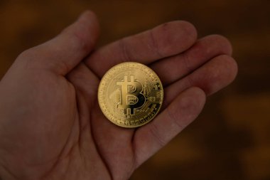 Kripto para birimi altın bitcoin. Elinde kripto para sembolü tutan adam - web bankacılığı ve uluslararası ağ ödemeleri için elektronik sanal para, seçici odaklanma, tonlama.