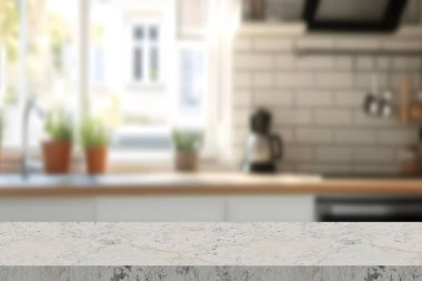 Boş taş beyaz masa. Mutfağın parlak iç kısmı. Bokeh 'in arkasındaki bulanık arka plan. 