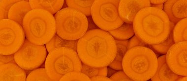 Arka plan olarak taze taze havuç dilimleri, üst manzara.