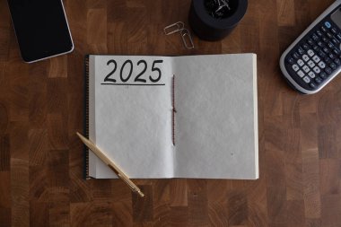 Yeni yıl kararları 2025 masada. 2025 gol listesi, defter, çay fincanı, kalem, ahşap masa. Kararlar, plan, hedefler, eylem, kontrol listesi, fikir konsepti. Yeni yıl 2025 kararları. Boşluğu kopyala