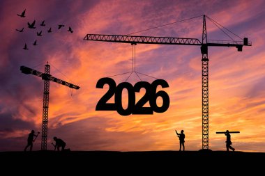 2026 yılı. Yeni yıl 2026. İnşaat vinci 2026 yılının rakamlarını ayarlıyor. Yeni Başlangıç motivasyonu, gün batımında siluet vinçte ilham verici bir alıntı mesajı. Hoş geldiniz. Mutlu yıllar 2026.