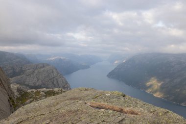 Preikestolen üzerinde duran ve fjerd, Preikestolen - Norveç dağlar, Norveç, ünlü cliff üzerinde seyir uzun yürüyüşe çıkan kimse
