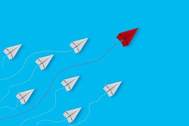 Kırmızı ve beyaz kağıt uçak yolu ve mavi arka planda rota çizgisi olan liderlik ya da farklı kavram