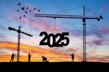 İnşaat vinçlerinin inşa edildiği inşaat alanının silueti 2025 yılının yeni yılını gün batımında karşılamaya hazır olun..