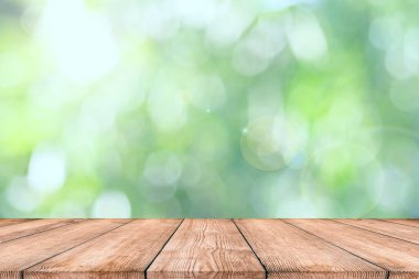 Doğa bahçesinde muz yaprağının bulanık yeşil arkaplanının üzerindeki doğal ahşap masa. Ürünlerinizi montaj veya görüntülemek için kullanılır..