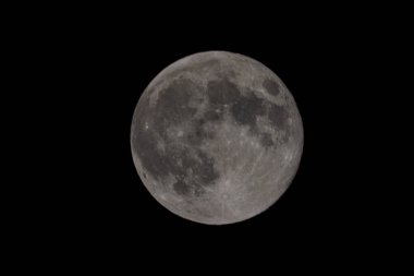 Ay, dingin güzelliğiyle gece gökyüzünü aydınlatıyor.